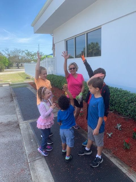 Adult and children waving