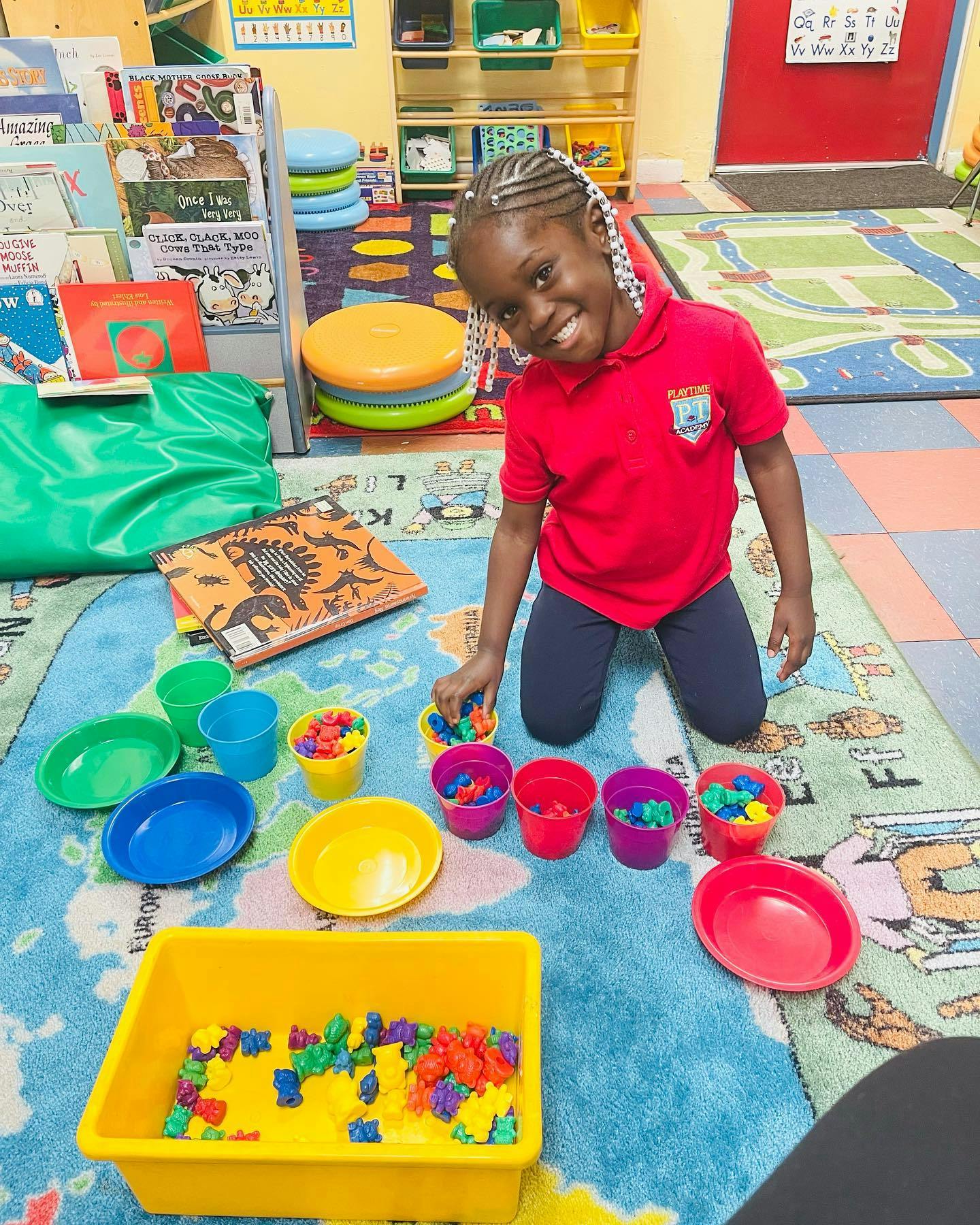 Child kneeling on a rug, sorting small colorful objects into cups
