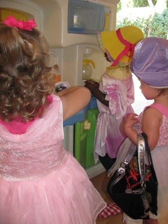 Three children playing in dress-up clothes