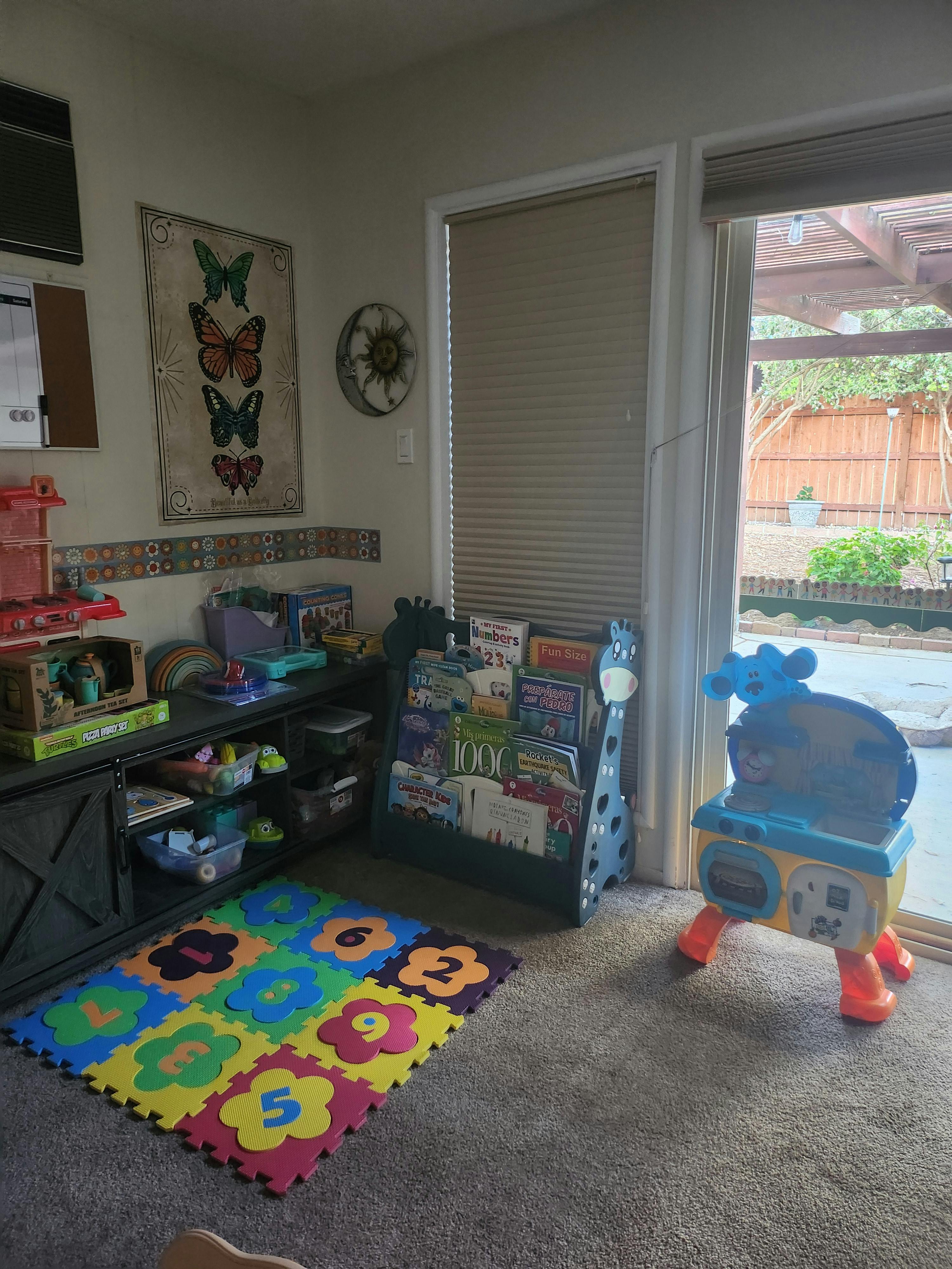 Playroom with a colorful number mat, toy shelf, and book display