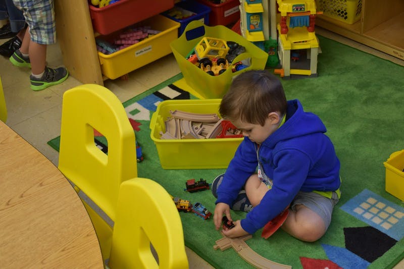 Child playing with toys on a green rug