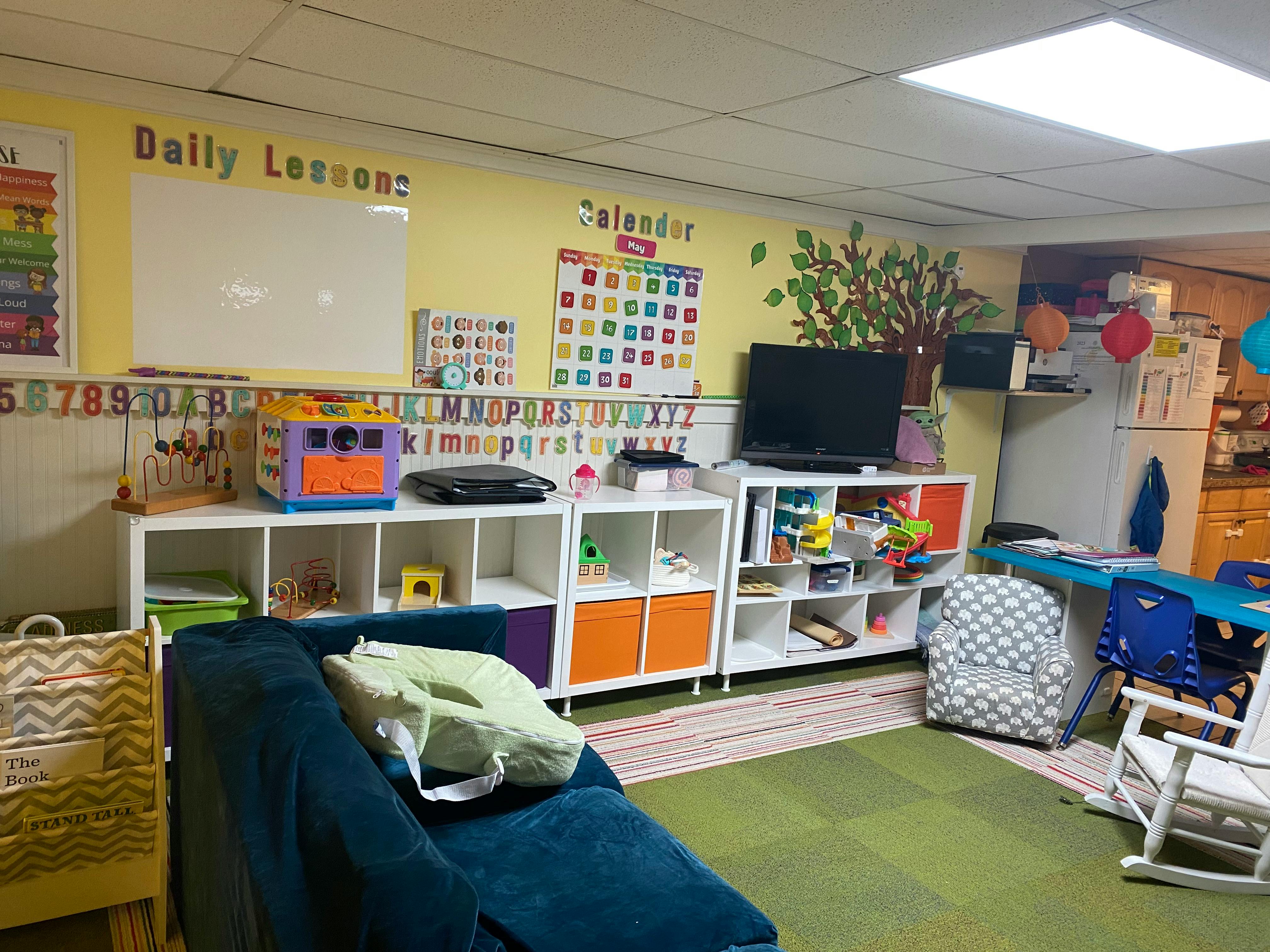 Classroom with whiteboard, calendar, shelves, and seating