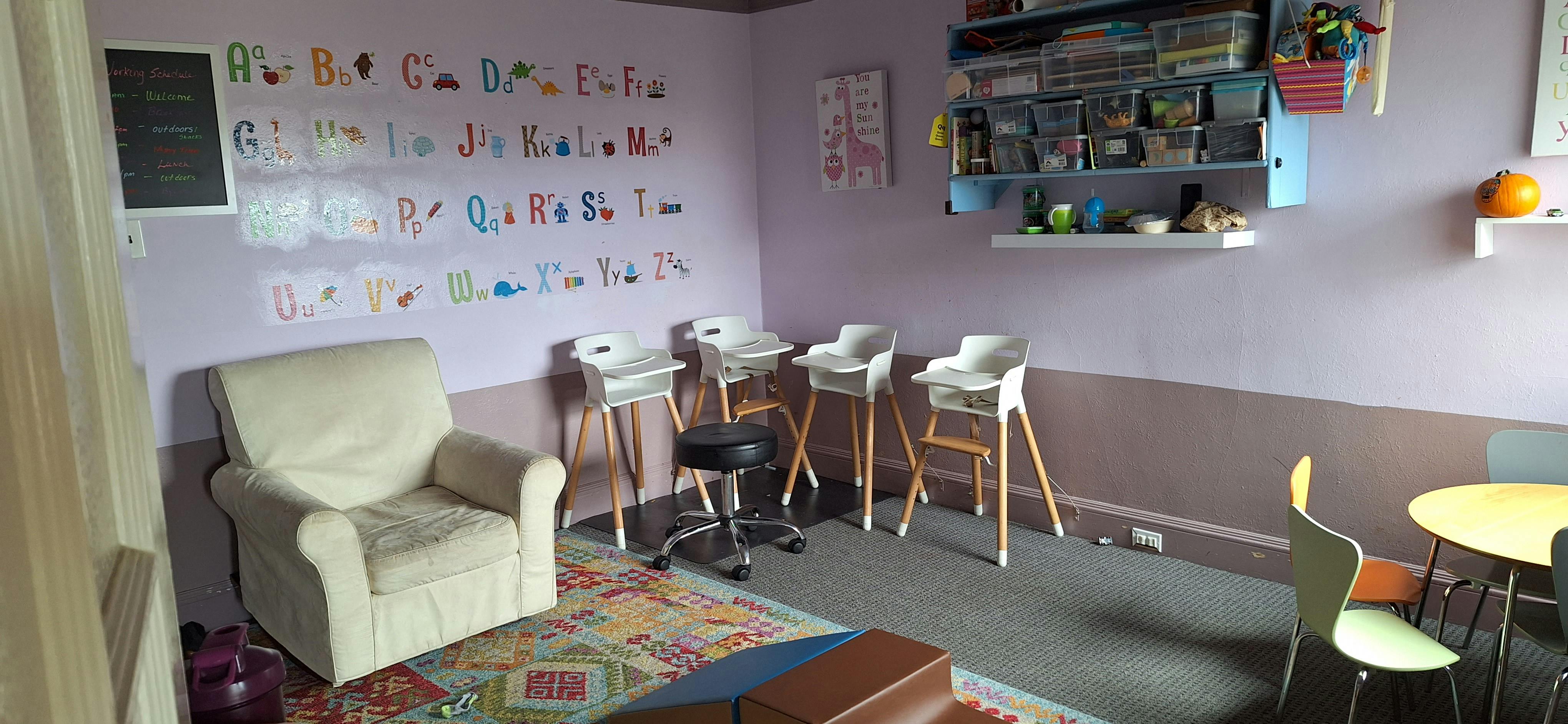 Room with an armchair, high chairs, and a small table with chairs