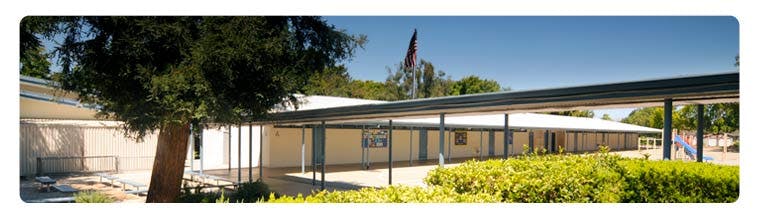 School building with covered walkway and trees