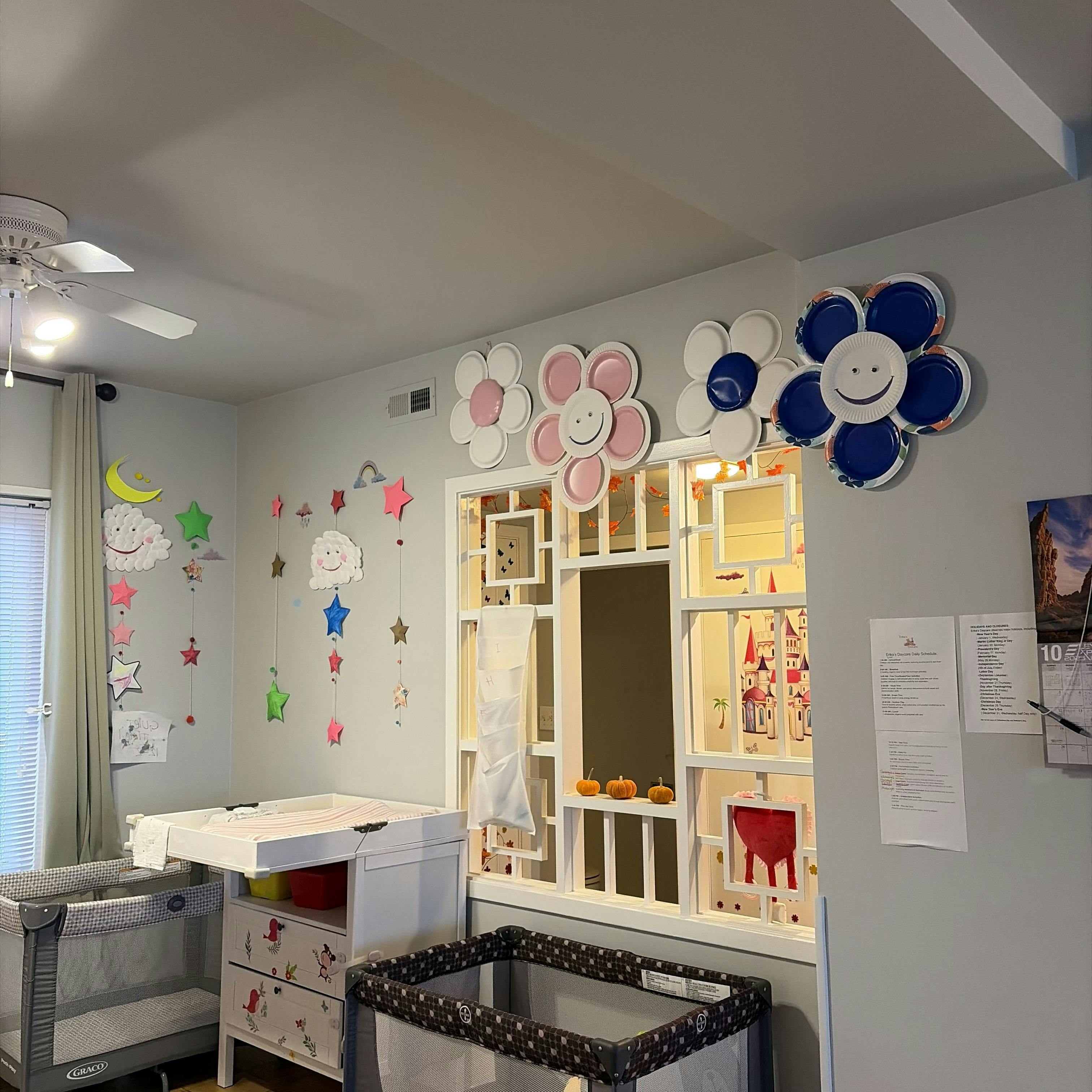 Nursery room with two cribs, a changing table, and wall decorations