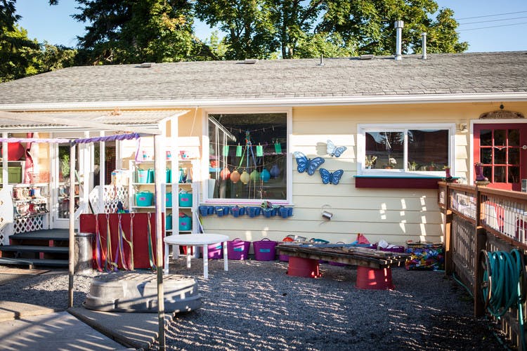 Outdoor play area next to a building with a red door and windows
