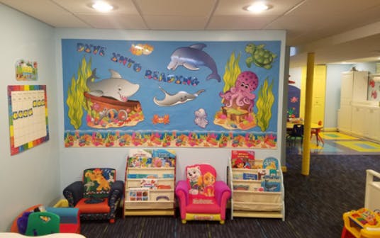 Children's play area with ocean-themed wall mural and small chairs