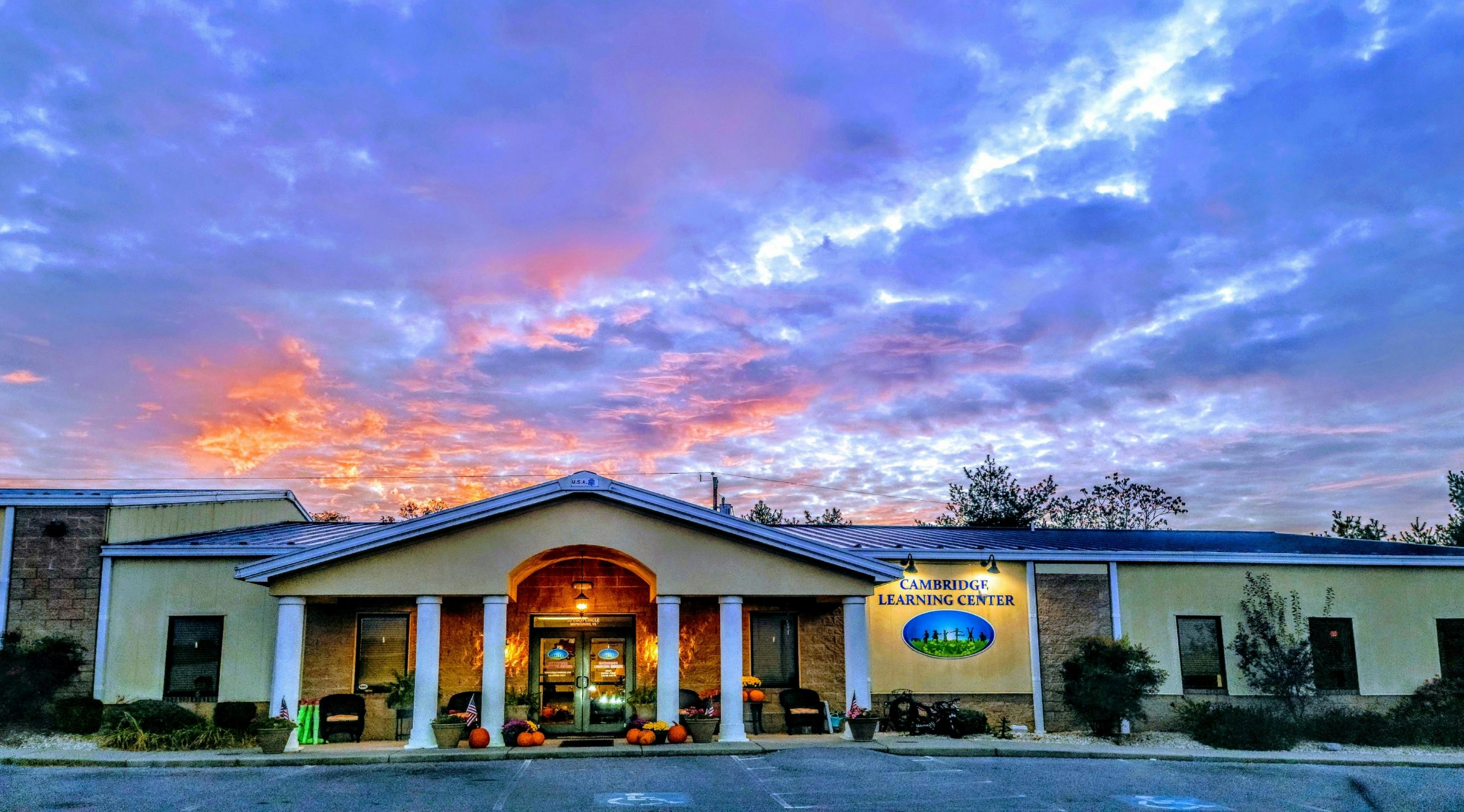 Building with columns under a colorful sunset sky