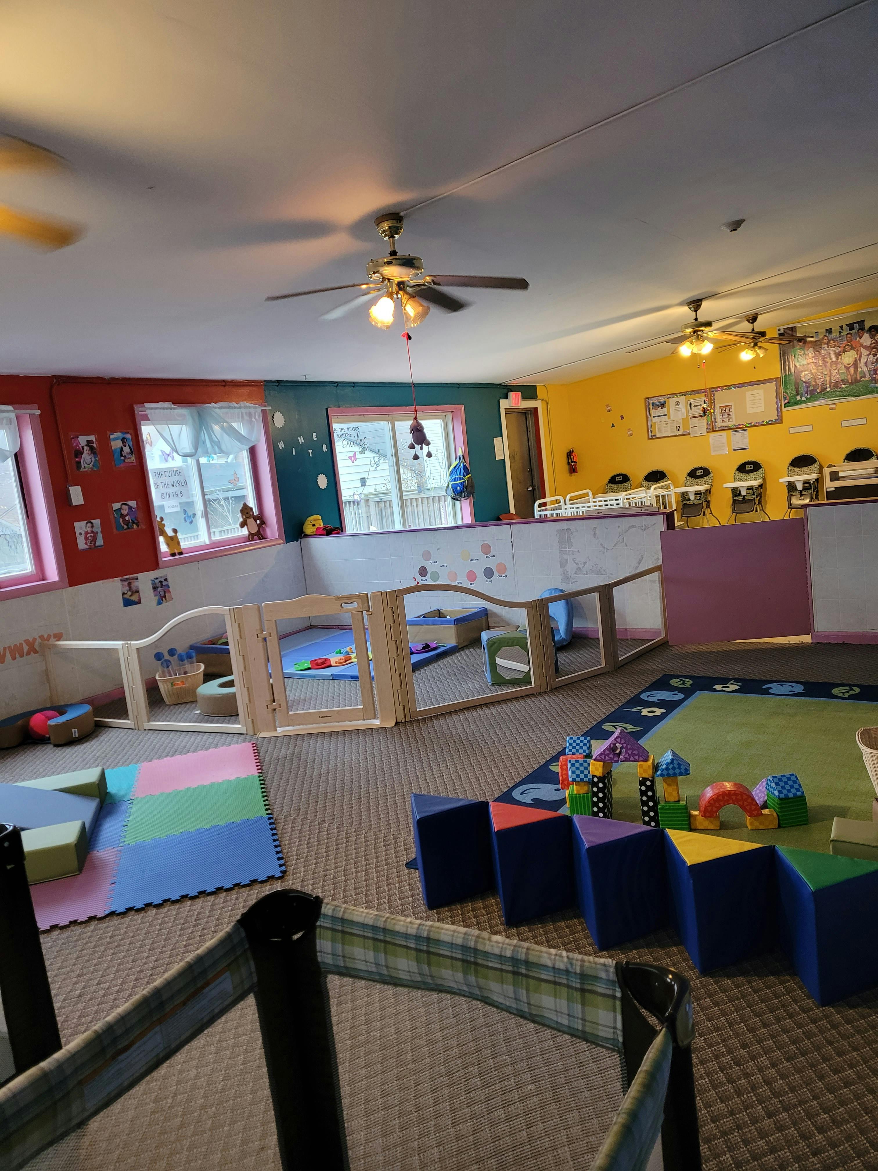 Playroom with soft play mats and a wooden playpen