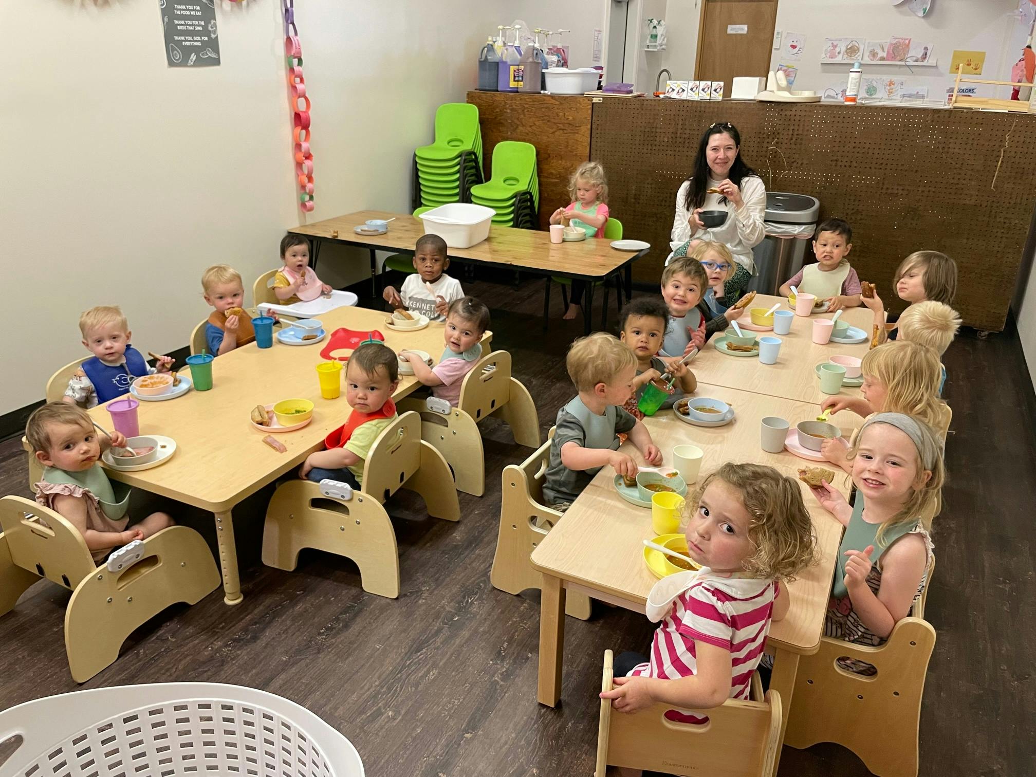 Children and an adult sitting at tables in a classroom