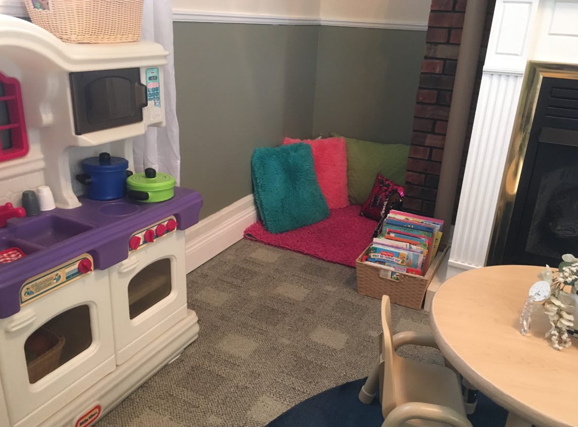 Play kitchen and reading nook with cushions and books
