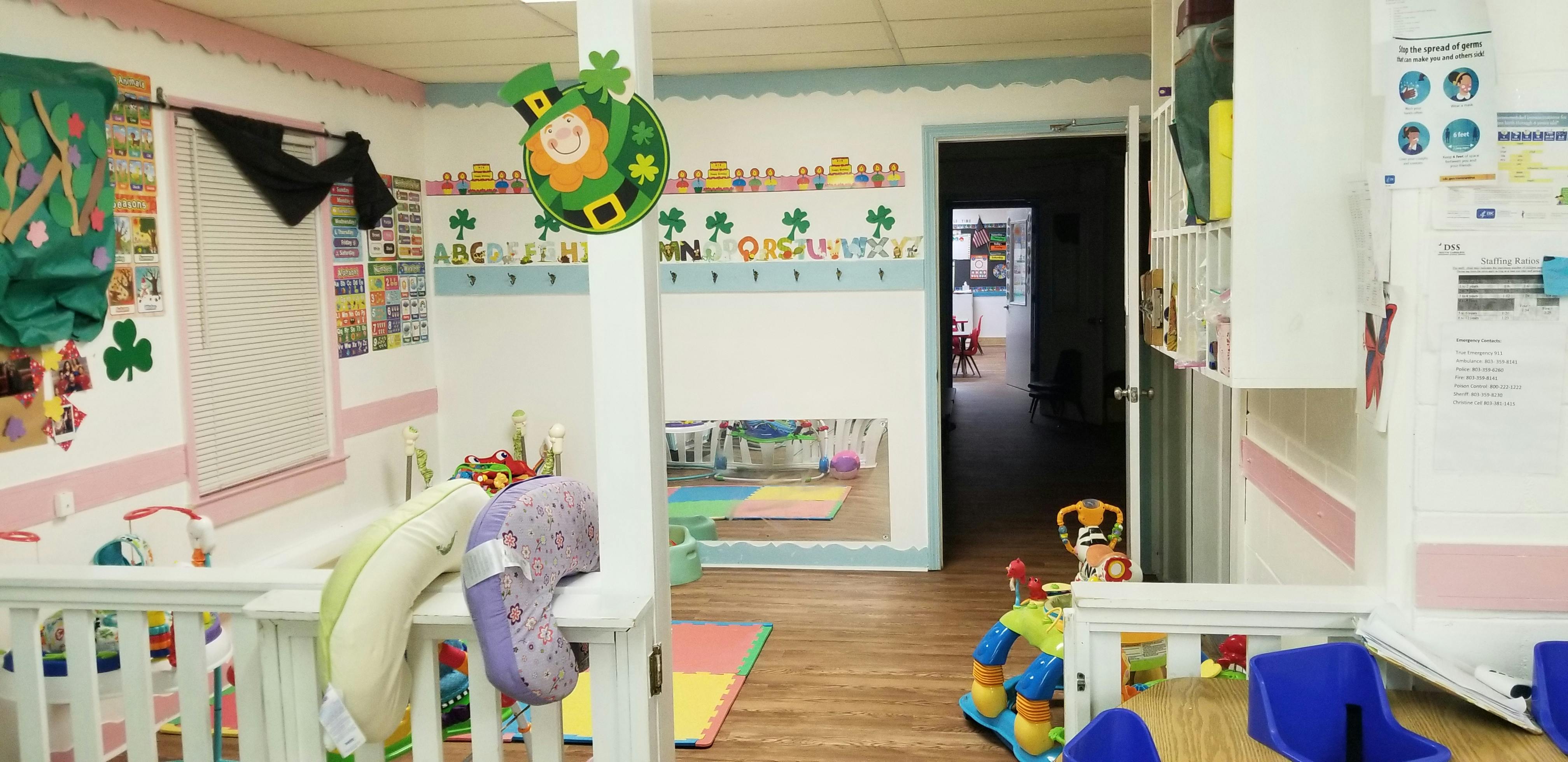 Childcare room with crib, toys, and decorations