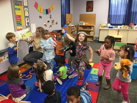 Adult reading to children in a classroom