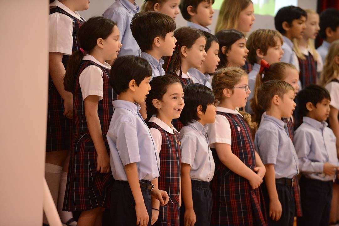 Group of children in school uniforms standing in rows