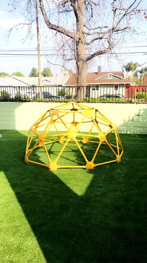 Yellow geodesic dome climber on green grass