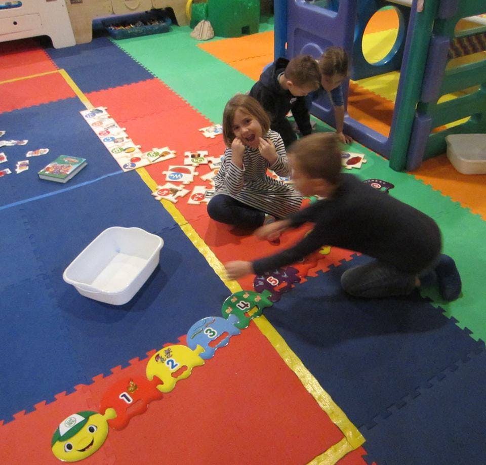 Children playing with toys on a colorful mat