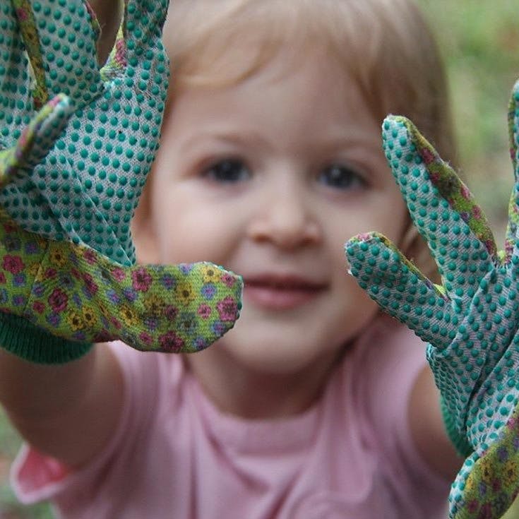 Child wearing gardening gloves