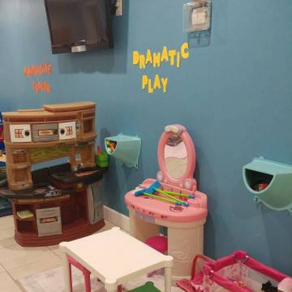 Play kitchen and vanity set in a room with "Dramatic Play" on the wall