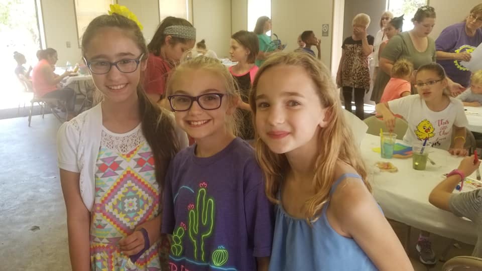Three children smiling at the camera