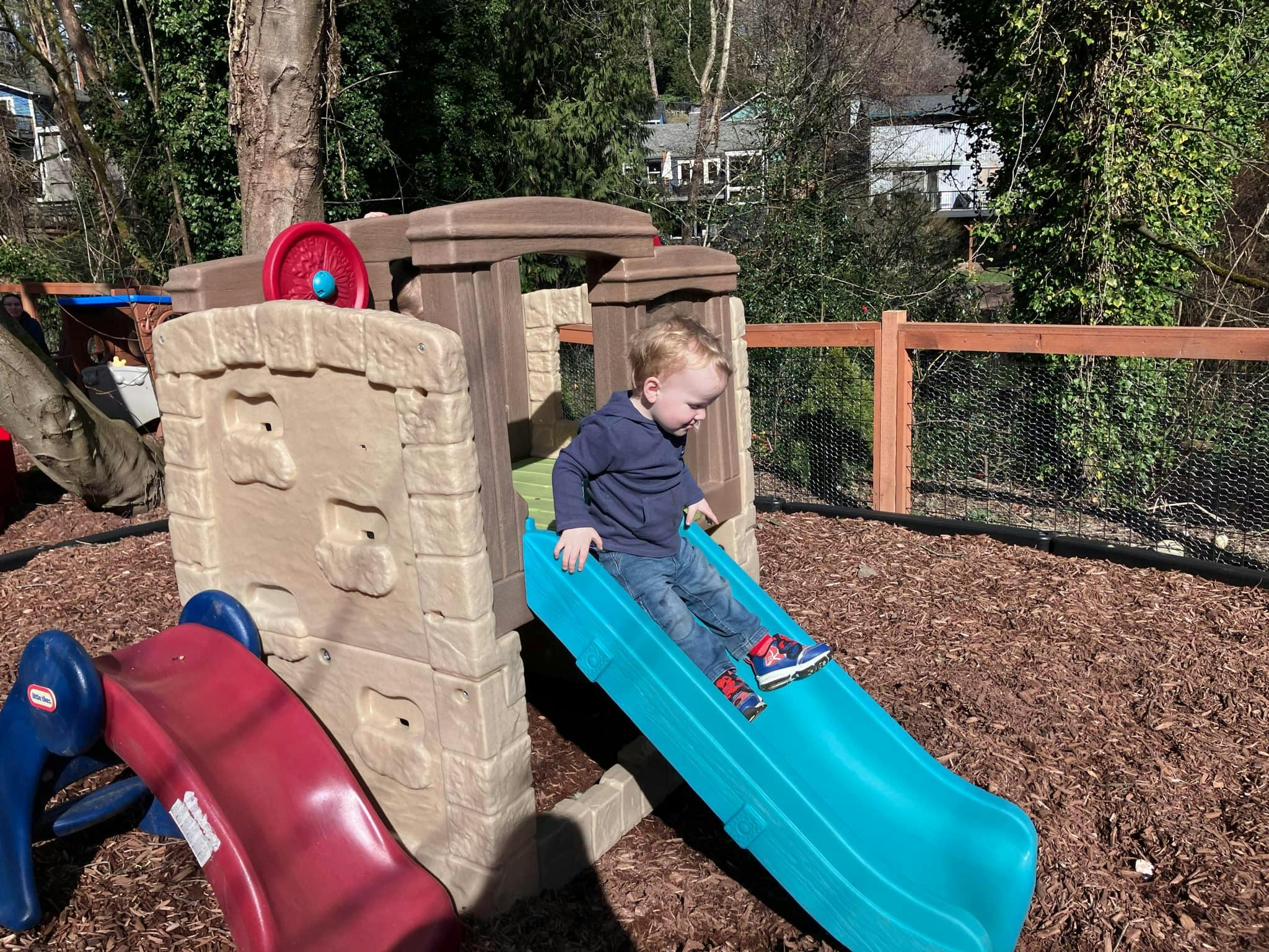 Child on a blue slide at a playground
