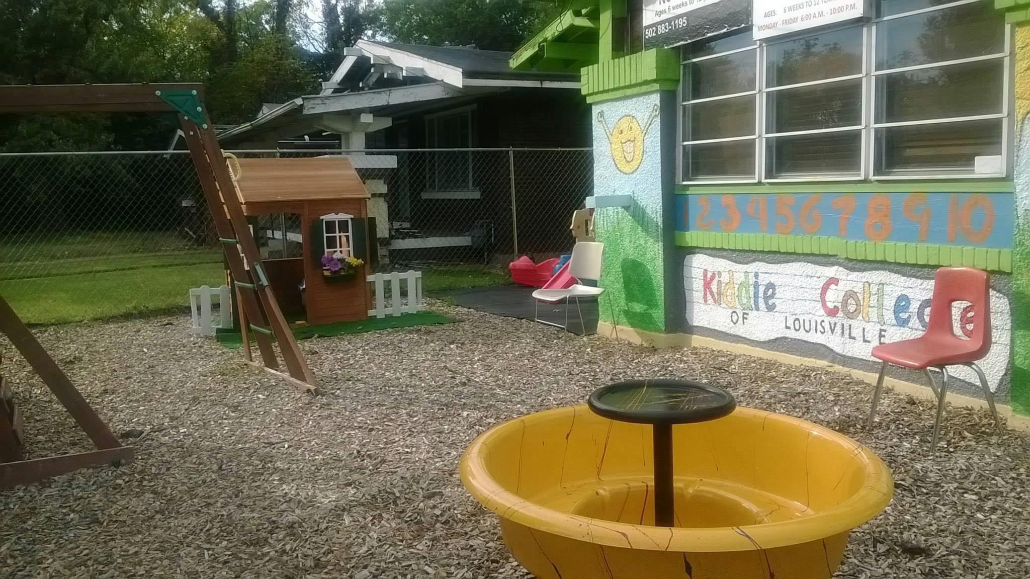 Playground with a small wooden playhouse and a yellow spinning toy