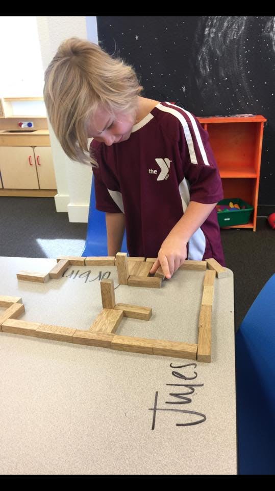 Child building with wooden blocks on a table