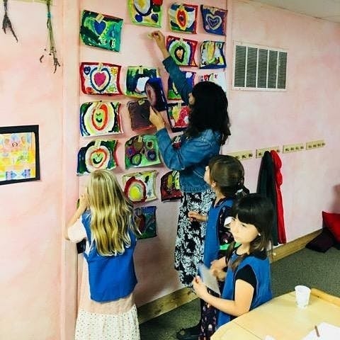 Person and children looking at colorful artwork on a wall