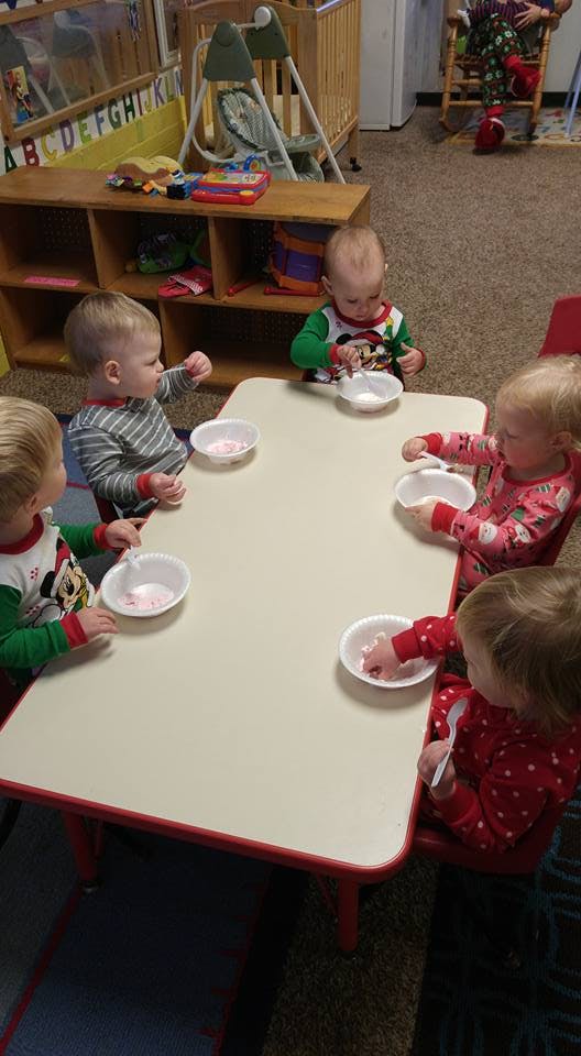 Four children sitting at a table with bowls