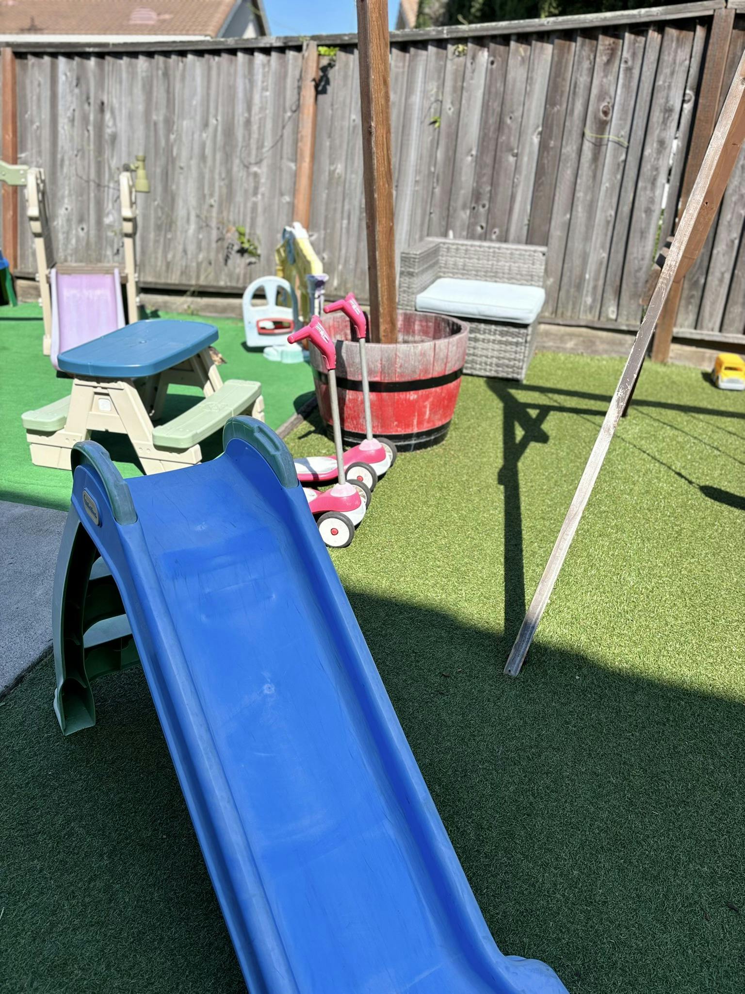 Blue slide and children's picnic table on artificial grass