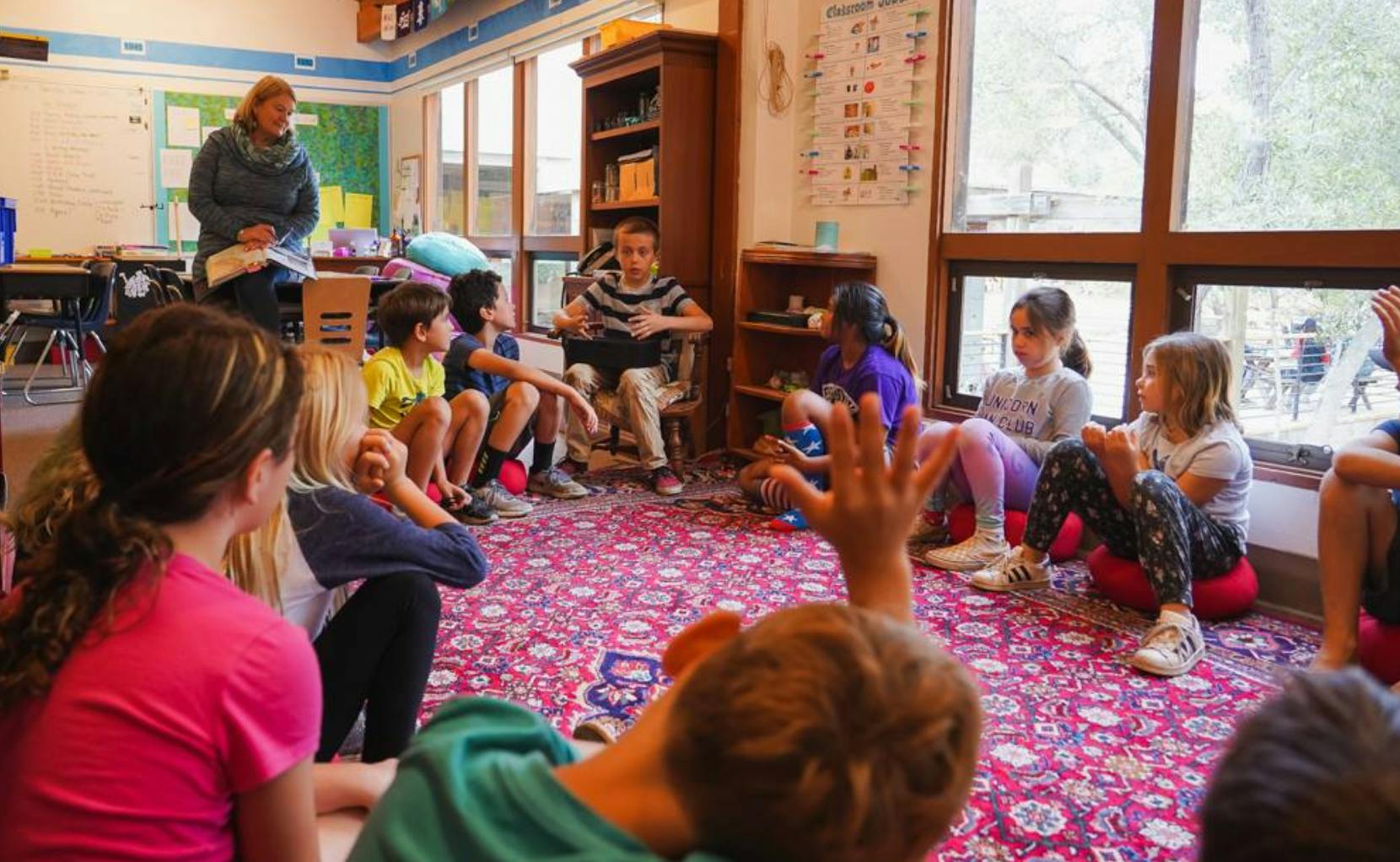 Adult and children sitting on floor in a classroom