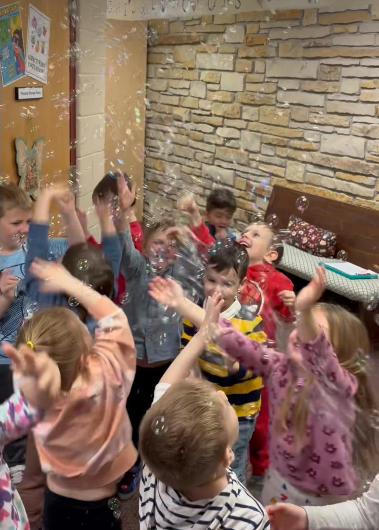 Group of children playing with bubbles indoors