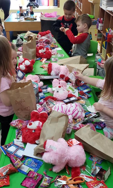 Children and teens sorting stuffed animals and candy on a table