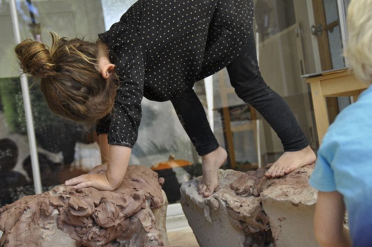 Child on hands and feet on two rock-like structures