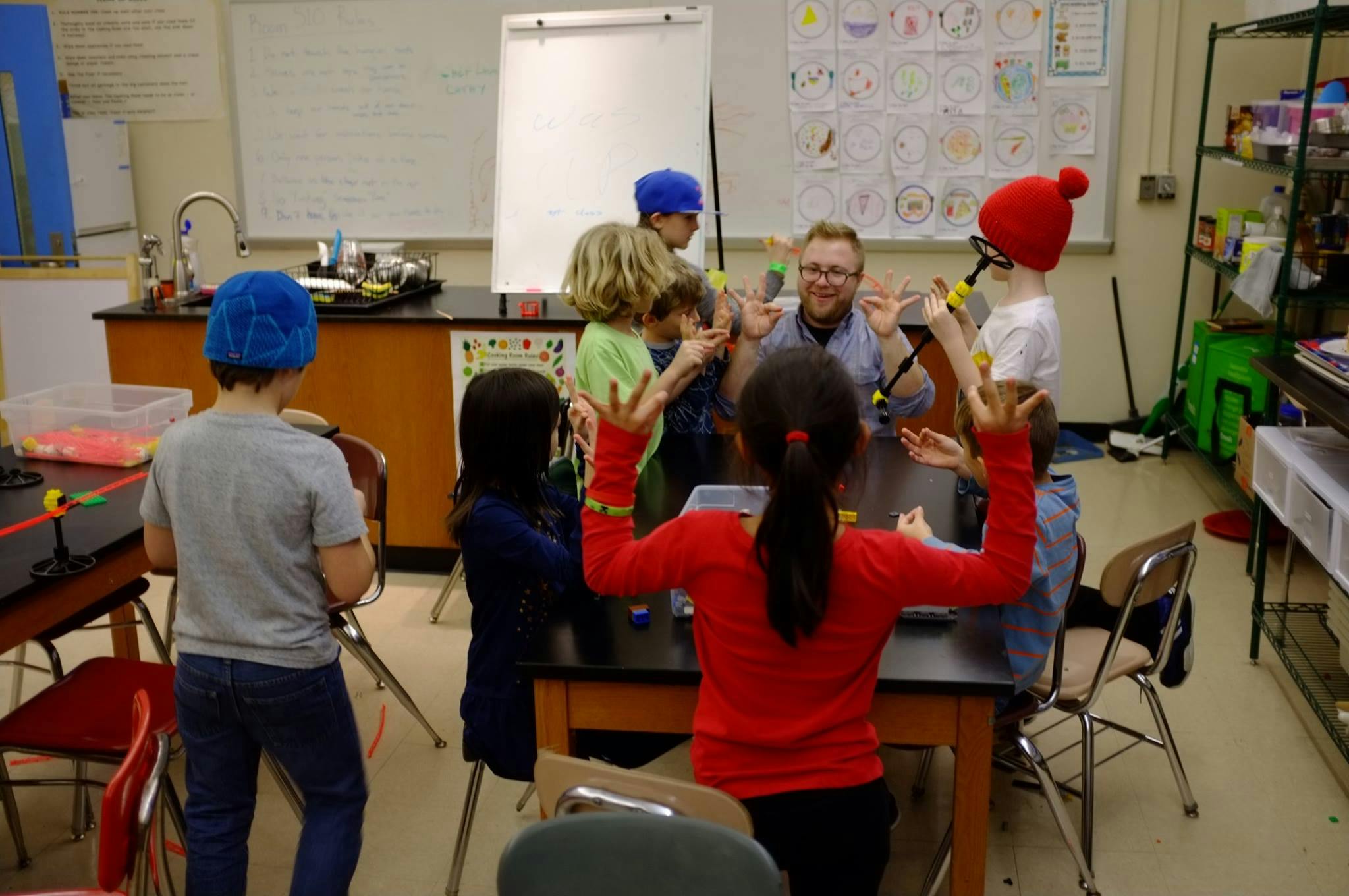 Adult and children gathered around a table in a classroom