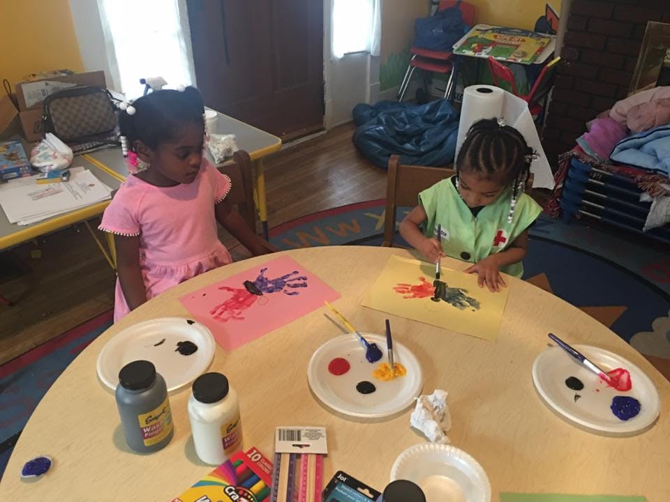 Two children painting at a table