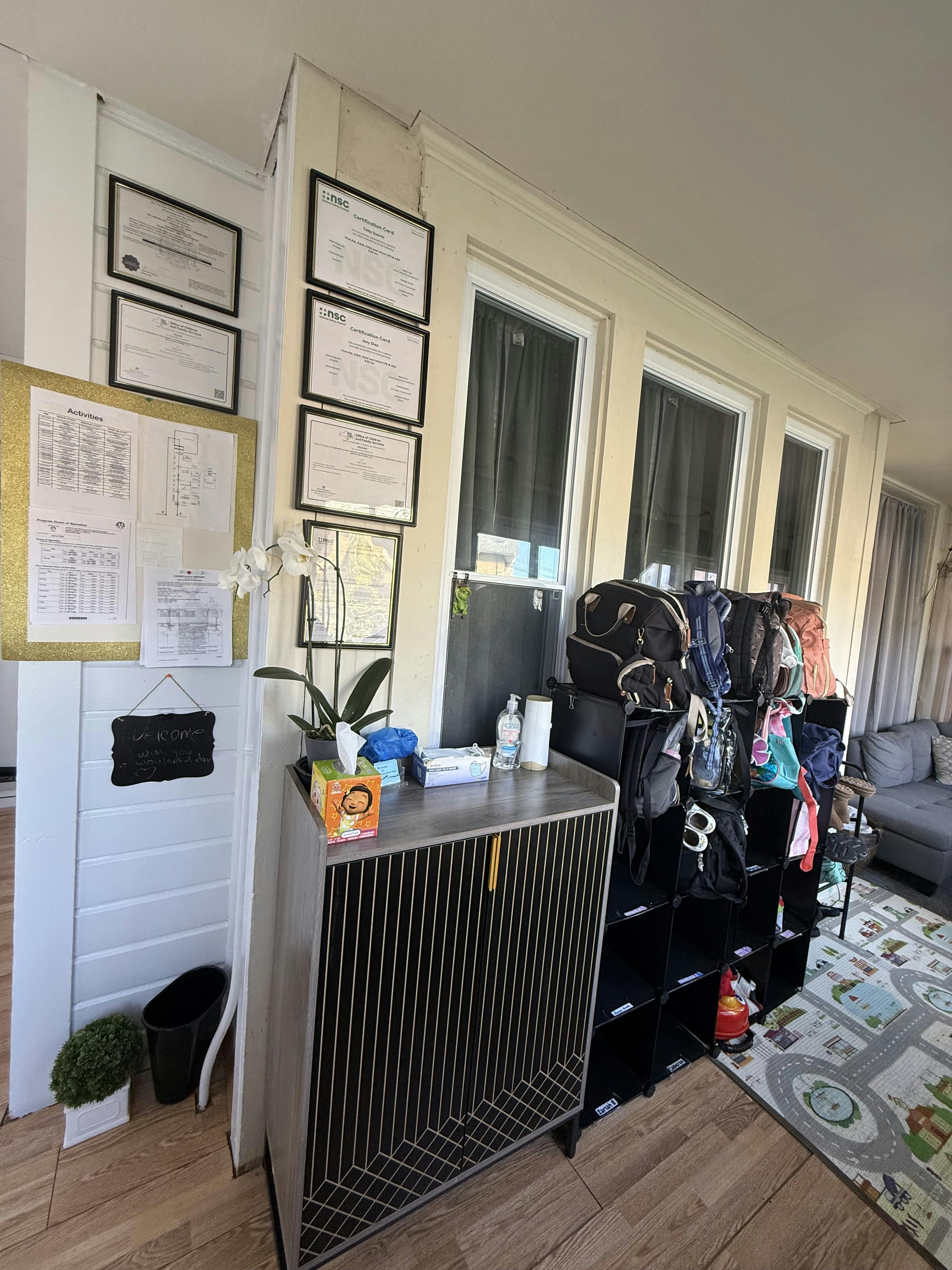 Wall with framed certificates and a storage unit with bags