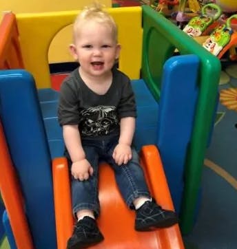 Child sitting on a colorful plastic slide