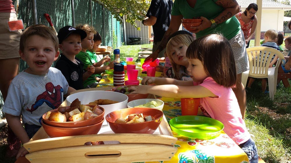 Children at a table with bowls of food