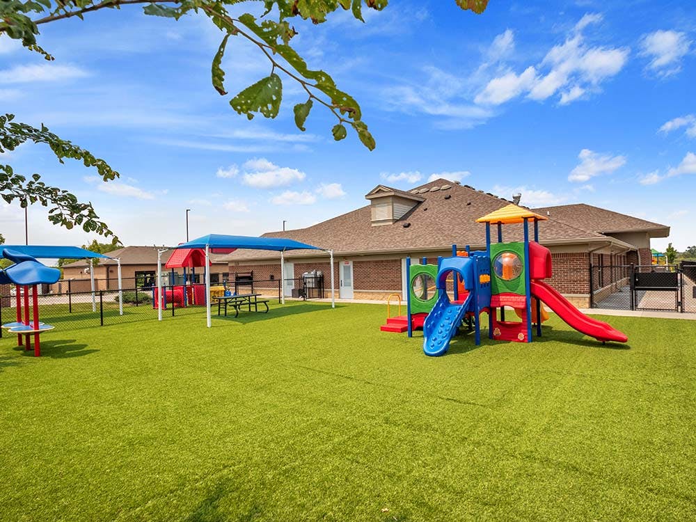 Colorful playground with slides and climbing structures on green artificial turf
