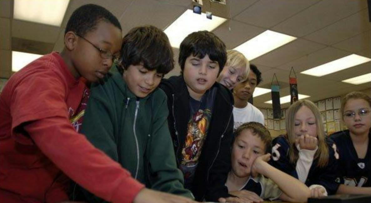 Group of children looking at something on a table