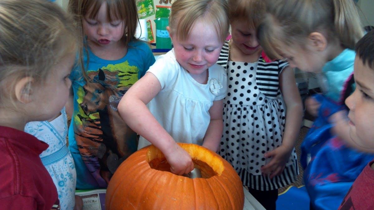 Children carving a pumpkin