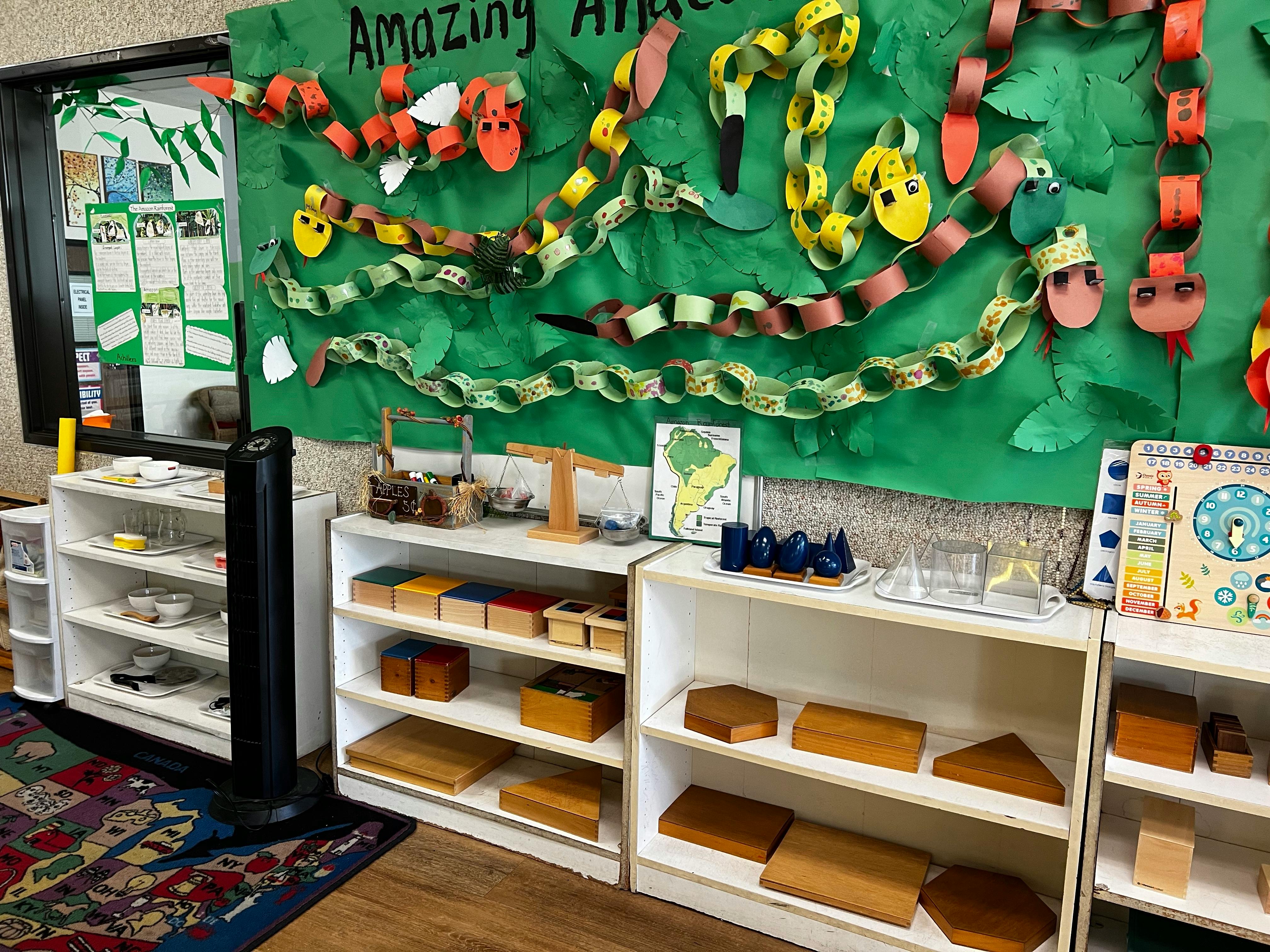 Classroom with shelves of learning materials and paper snake decorations