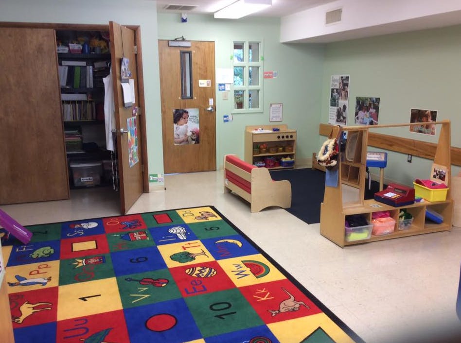 Classroom with colorful alphabet rug and wooden furniture