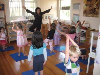 Adult and children doing yoga poses in a room