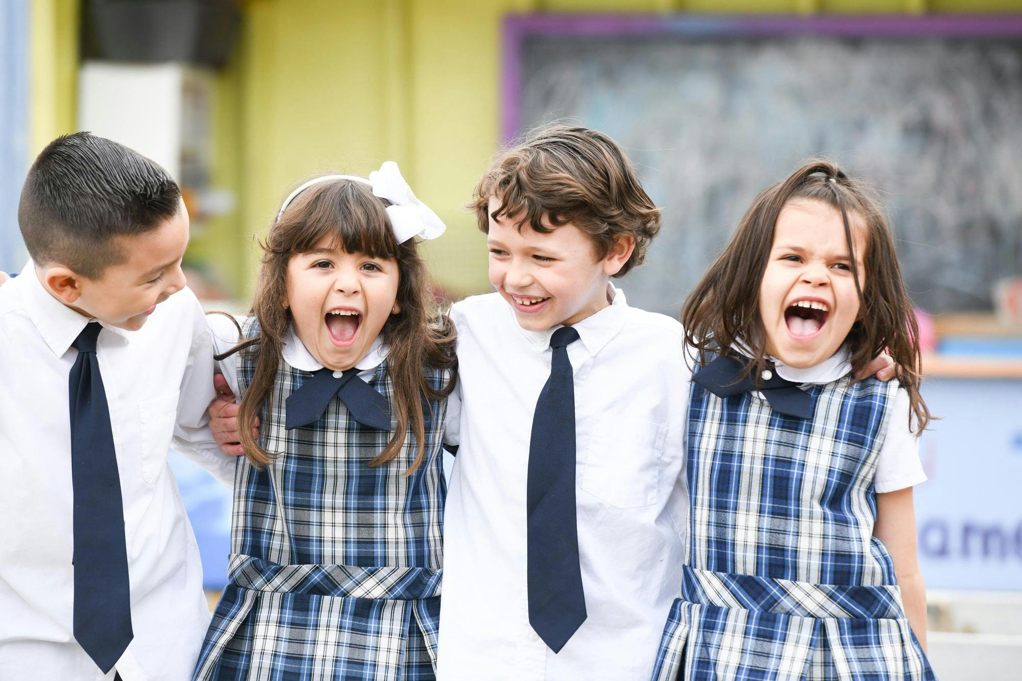 Four children in uniform laughing and shouting