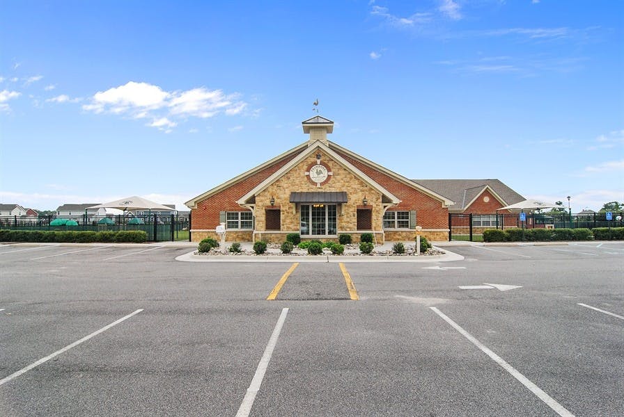Building with a clock tower and a parking lot in front