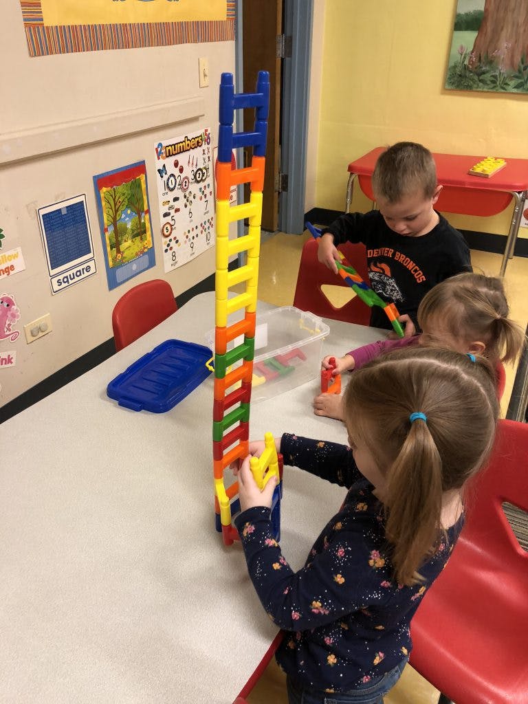 Children playing with colorful building blocks at a table