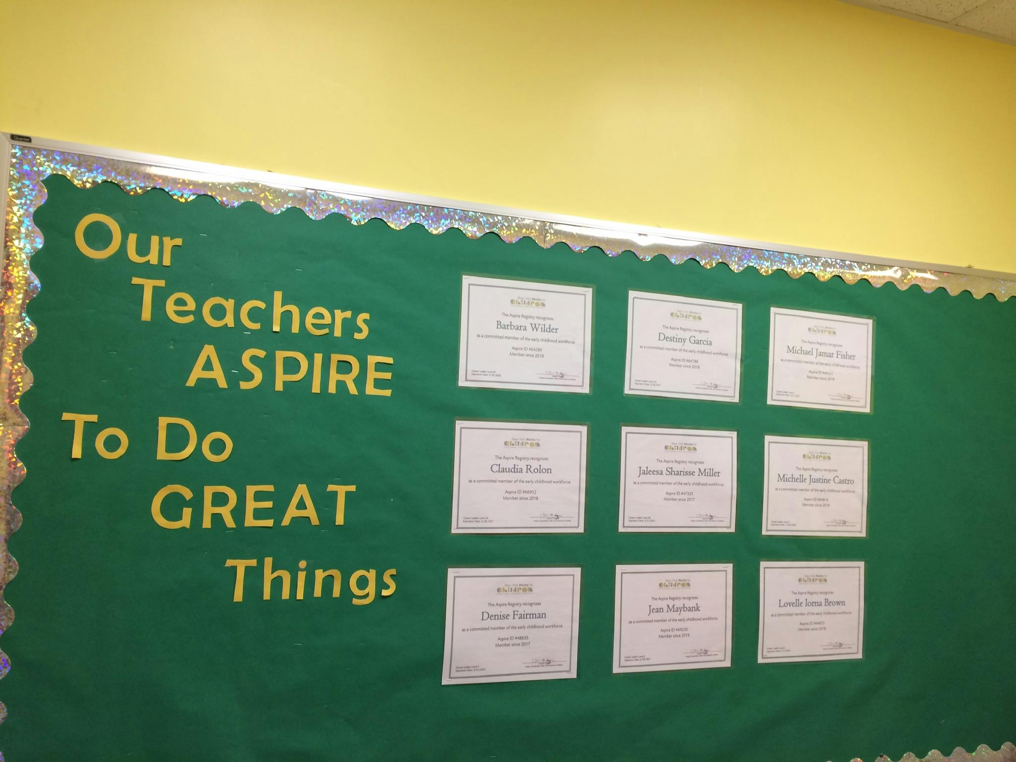 Bulletin board with text "Our Teachers ASPIRE To Do GREAT Things" and certificates