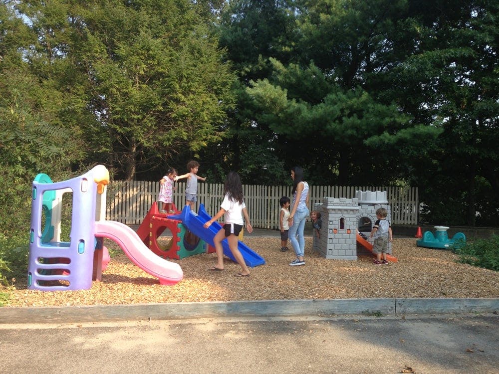 Children and adults on a playground with slides and play structures