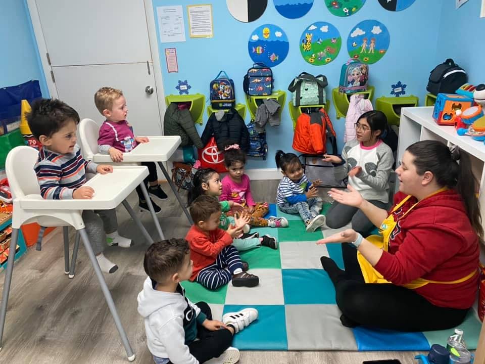 Adult and children sitting on floor in a classroom